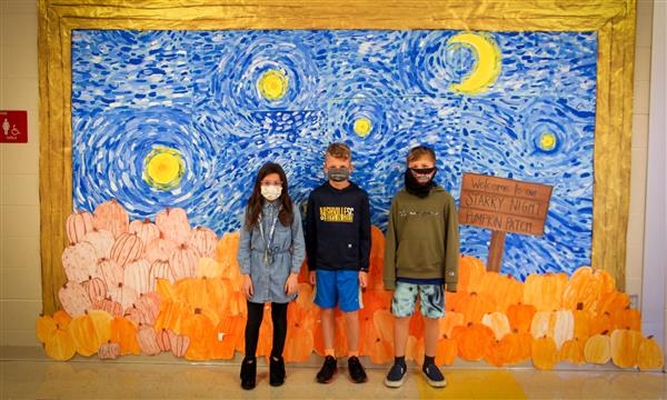Students stand in front of Starry Night painting